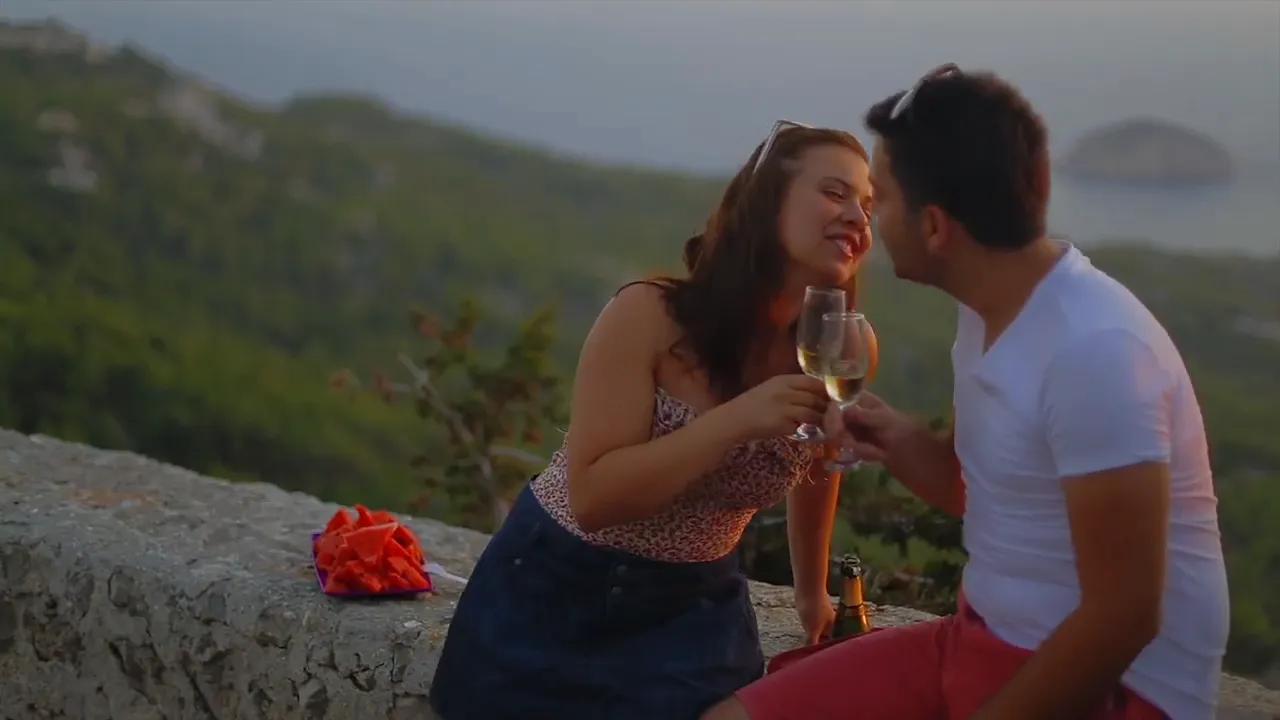 A couple raising a glass at sunset in Rhodes